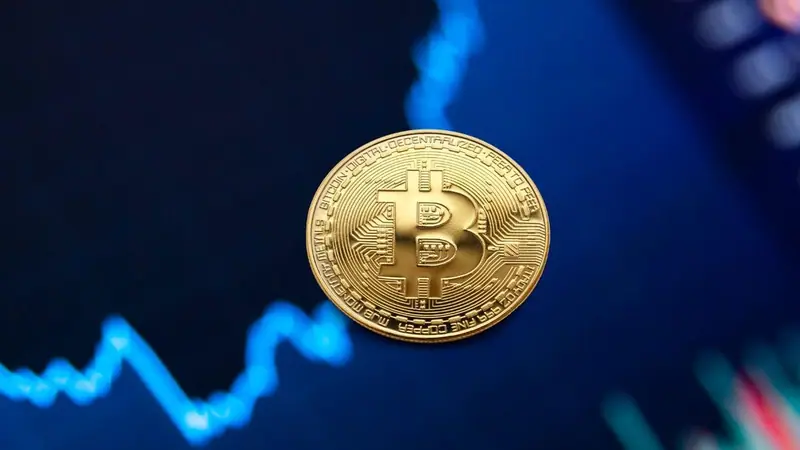 Moneda de Bitcoin sobre un gráfico azul