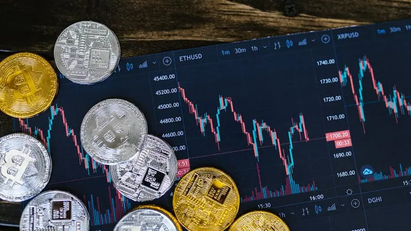 Monedas de criptomonedas junto a un gráfico de precios