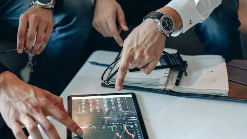Personas analizando datos de mercado en una tableta