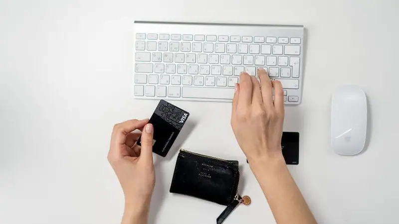 Manos manejando un dispositivo pequeño junto a un teclado