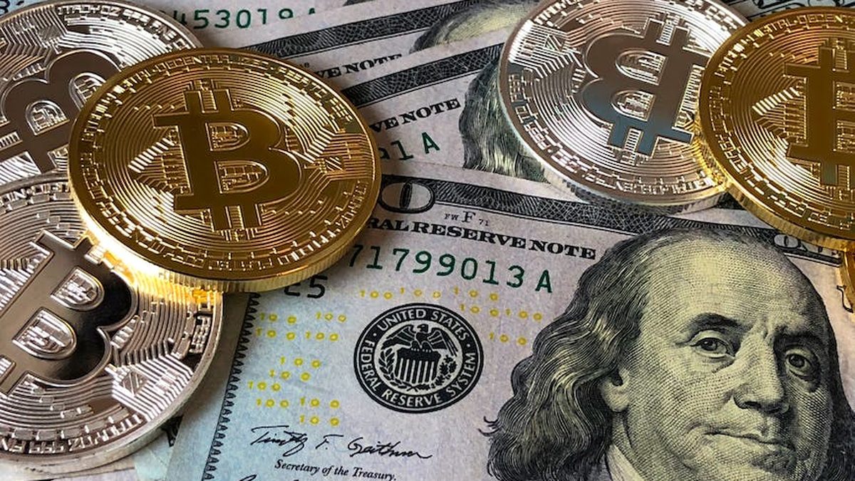 Monedas de Bitcoin sobre billetes de dólar